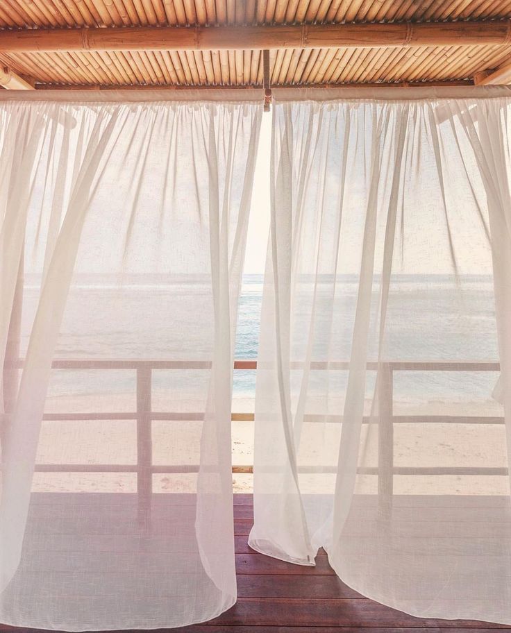 Cool coastal breeze visualized through sheer curtains over calm seating